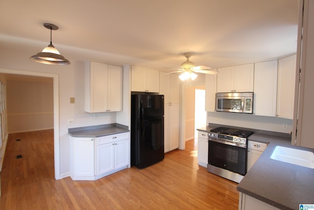 kitchen featuring white cabinets, appliances with stainless steel finishes, and light hardwood / wood-style flooring