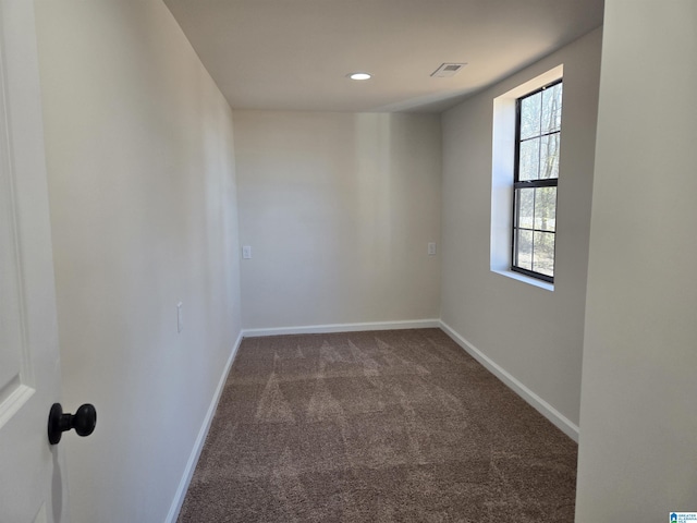 unfurnished room with dark carpet