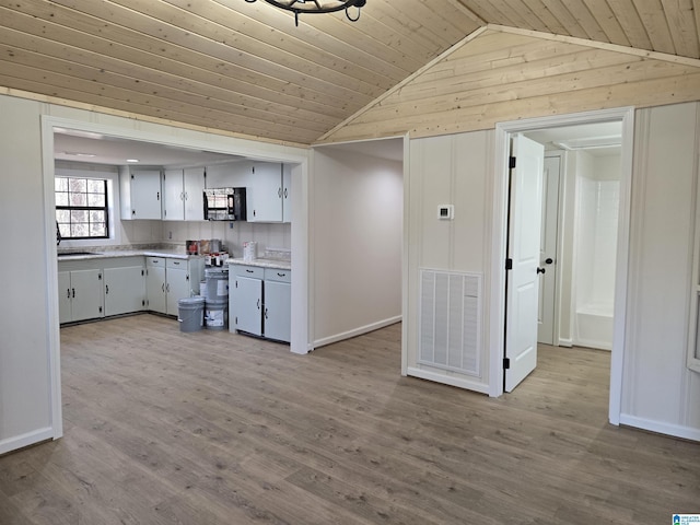 kitchen with wooden ceiling, lofted ceiling, backsplash, and light hardwood / wood-style floors