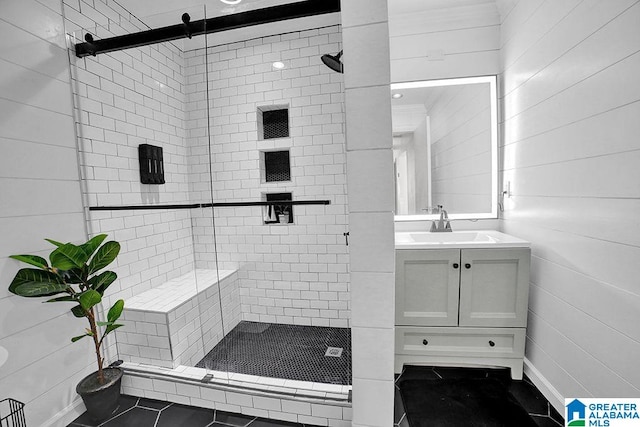 bathroom featuring tile patterned floors, a shower with door, wood walls, and vanity