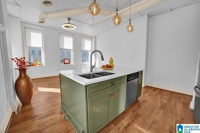 kitchen with hanging light fixtures, green cabinetry, stainless steel dishwasher, light hardwood / wood-style flooring, and sink