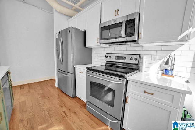 kitchen featuring light hardwood / wood-style floors, backsplash, stainless steel appliances, and white cabinetry