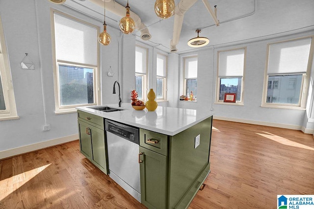 kitchen with sink, a kitchen island with sink, dishwasher, and green cabinetry