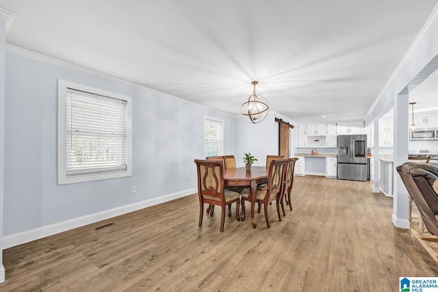 dining room with light wood-type flooring, an inviting chandelier, and ornamental molding