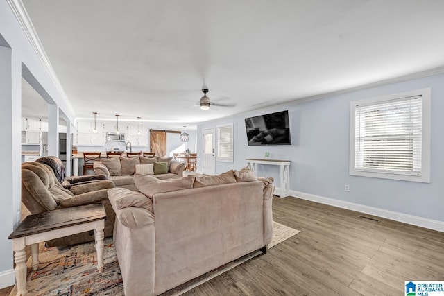 living room with ceiling fan, crown molding, and hardwood / wood-style flooring