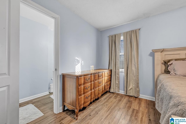 bedroom featuring a textured ceiling and light hardwood / wood-style floors