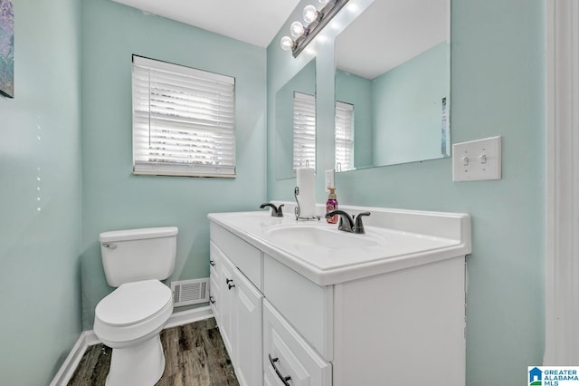 bathroom with toilet, hardwood / wood-style floors, and vanity