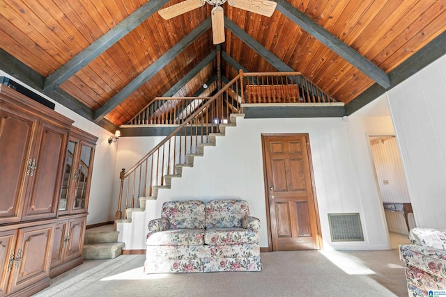 unfurnished living room with high vaulted ceiling, beam ceiling, and light carpet