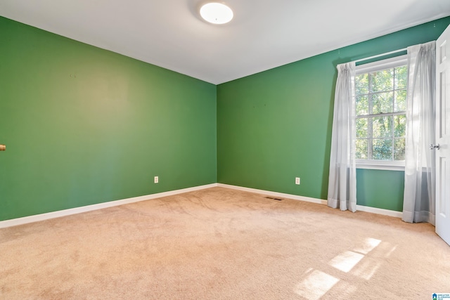 unfurnished room featuring light carpet