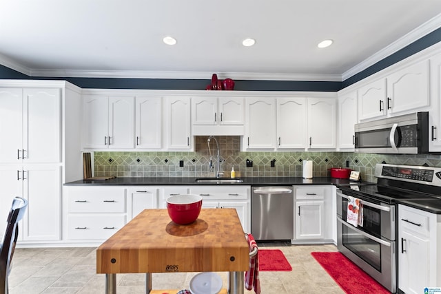 kitchen featuring sink, appliances with stainless steel finishes, white cabinetry, backsplash, and ornamental molding