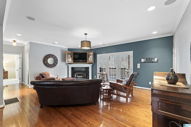 living room featuring ornamental molding and light hardwood / wood-style flooring