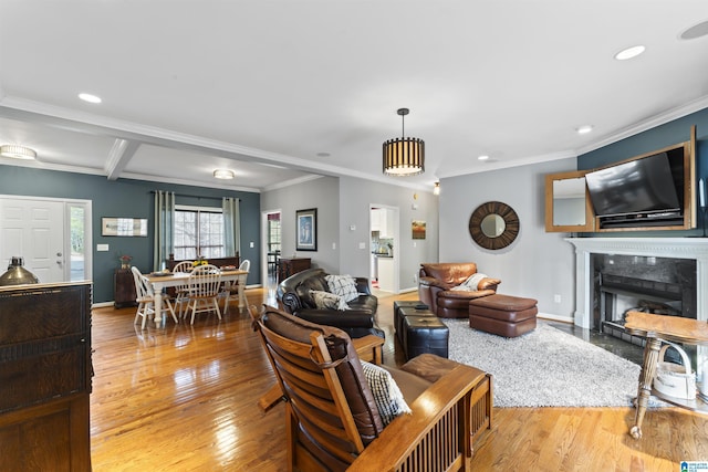 living room featuring ornamental molding, a high end fireplace, and light hardwood / wood-style flooring