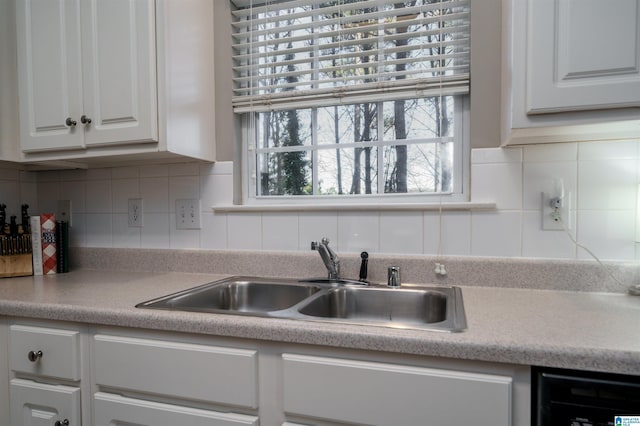 kitchen featuring sink, white cabinetry, dishwasher, and tasteful backsplash