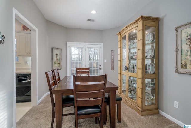 dining area featuring light carpet