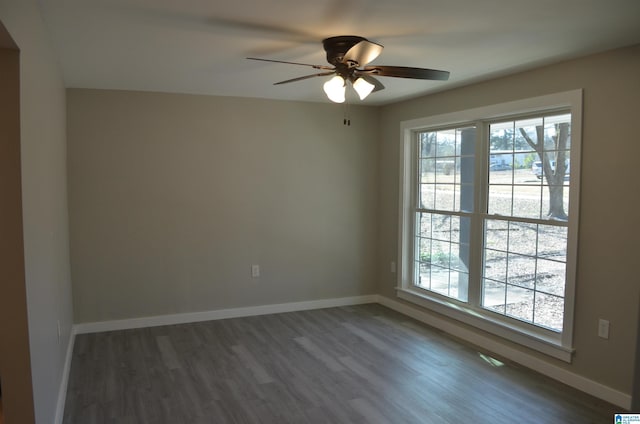 spare room featuring dark wood-type flooring and ceiling fan