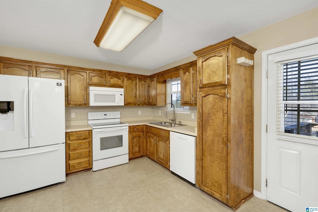 kitchen with a textured ceiling, sink, and white appliances