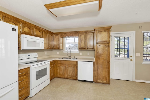 kitchen featuring sink, white appliances, a wealth of natural light, and a textured ceiling