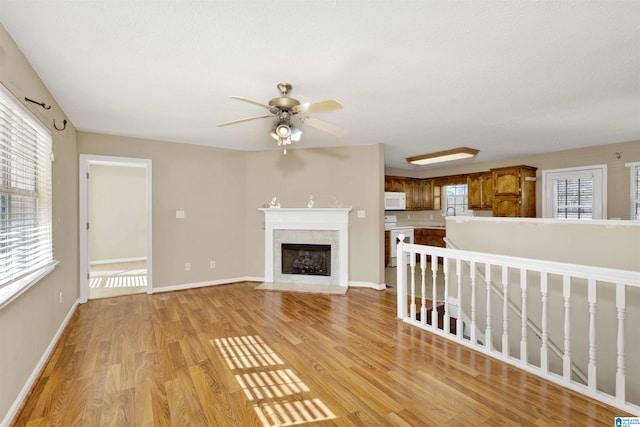 unfurnished living room featuring ceiling fan, sink, and light hardwood / wood-style flooring