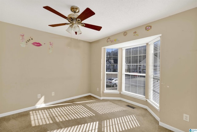 spare room with ceiling fan and carpet