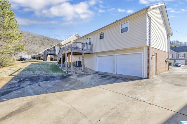 view of front of house featuring a garage, a deck with mountain view, and cooling unit