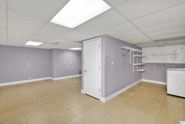 basement featuring a paneled ceiling and washer / clothes dryer