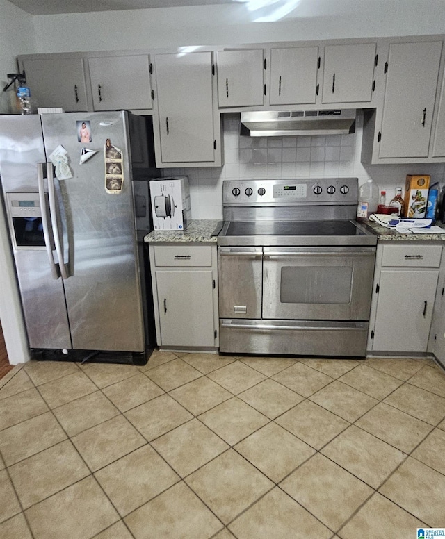 kitchen with light tile patterned floors, appliances with stainless steel finishes, and tasteful backsplash