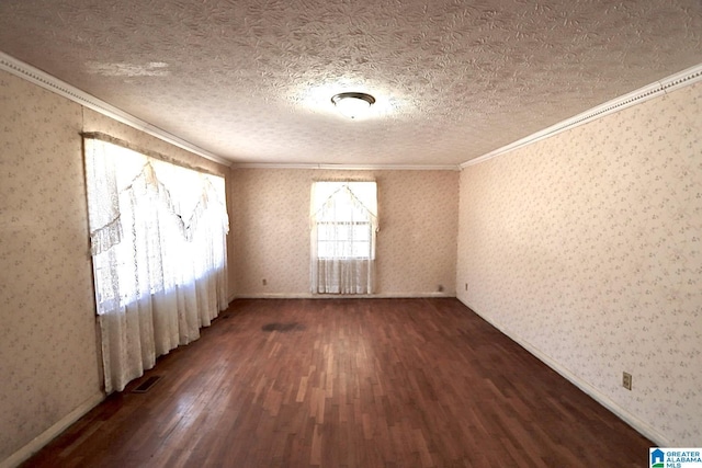 spare room with a textured ceiling, dark hardwood / wood-style flooring, and ornamental molding