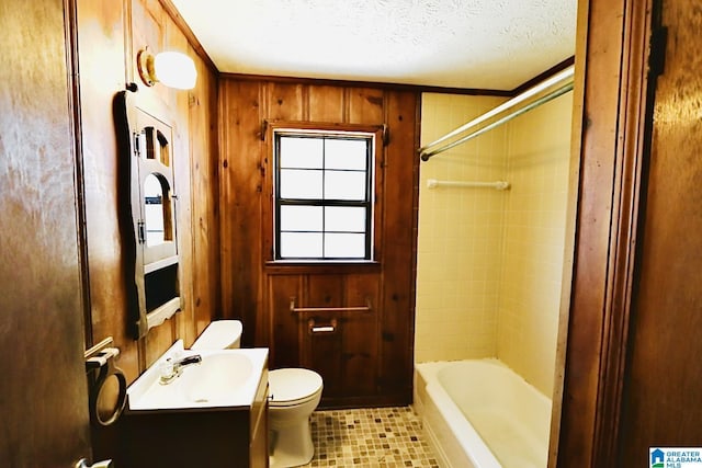 bathroom with a textured ceiling, toilet, vanity, and wood walls