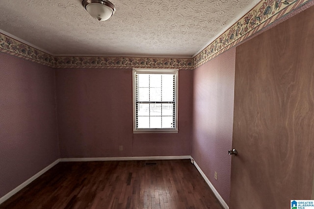 unfurnished room with a textured ceiling and dark hardwood / wood-style flooring