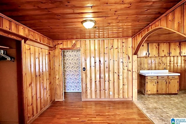 interior space featuring wooden walls, light hardwood / wood-style floors, and wooden ceiling