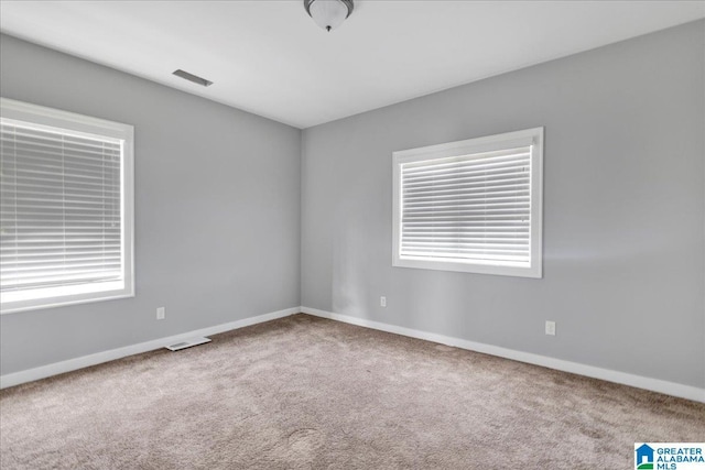 unfurnished room featuring plenty of natural light and carpet flooring