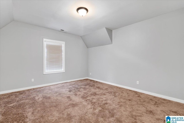 additional living space featuring carpet floors and vaulted ceiling