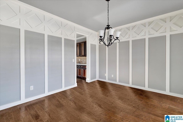 unfurnished dining area featuring an inviting chandelier and dark hardwood / wood-style floors