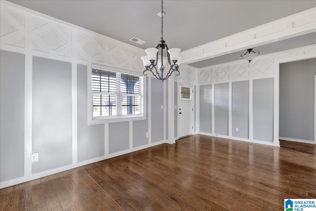 unfurnished dining area with a chandelier and dark hardwood / wood-style flooring