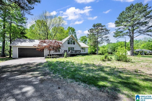 view of front facade featuring a front lawn, a garage, and a wooden deck