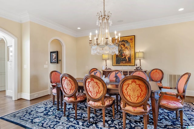 dining room featuring ornamental molding, a chandelier, and hardwood / wood-style flooring