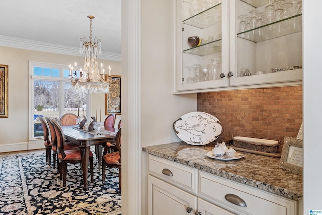 dining space with a notable chandelier and ornamental molding