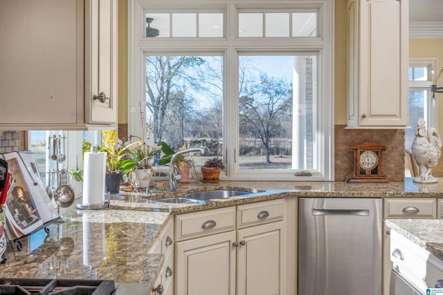 kitchen with stainless steel dishwasher, decorative backsplash, sink, crown molding, and light stone counters