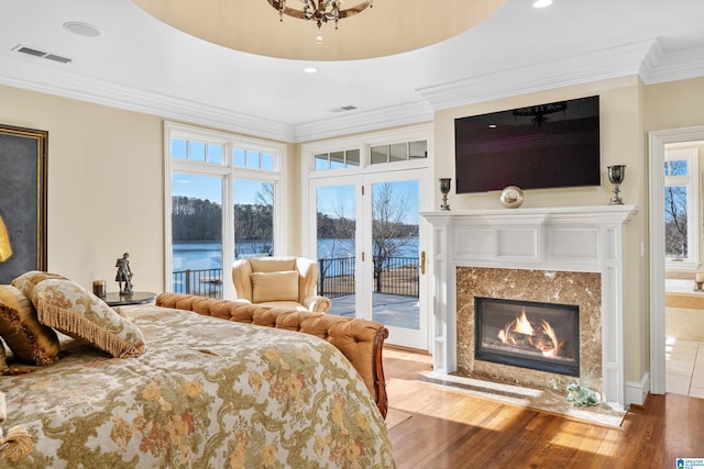 bedroom with access to outside, a fireplace, ornamental molding, and hardwood / wood-style floors