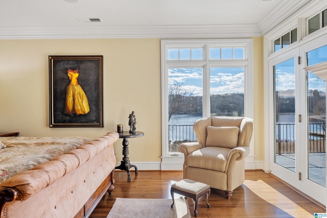 sitting room with hardwood / wood-style flooring, crown molding, and plenty of natural light