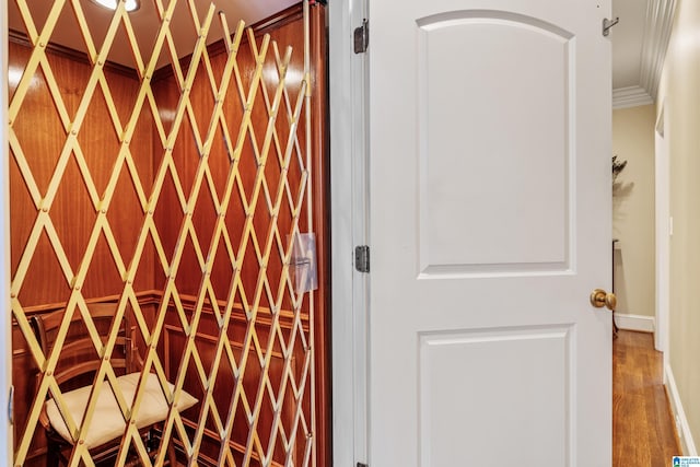 wine area with ornamental molding and hardwood / wood-style flooring