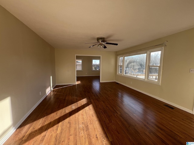 unfurnished living room featuring ceiling fan and dark hardwood / wood-style flooring