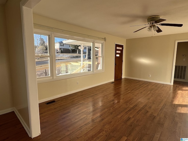 unfurnished living room featuring dark wood-type flooring and ceiling fan