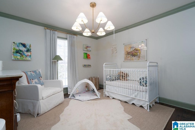 bedroom featuring a notable chandelier, a nursery area, crown molding, and hardwood / wood-style floors