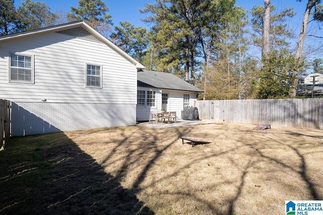 rear view of house featuring a lawn and a patio