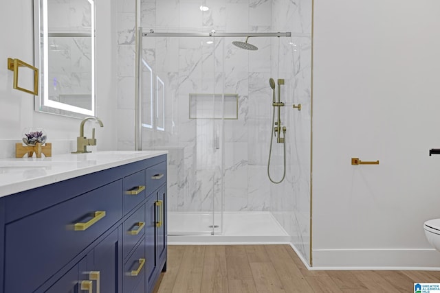 bathroom featuring vanity, toilet, a shower with shower door, and wood-type flooring