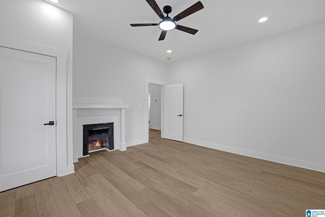 unfurnished living room featuring ceiling fan and light hardwood / wood-style floors