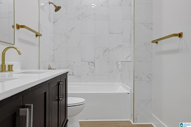 full bathroom featuring vanity, tiled shower / bath, and toilet