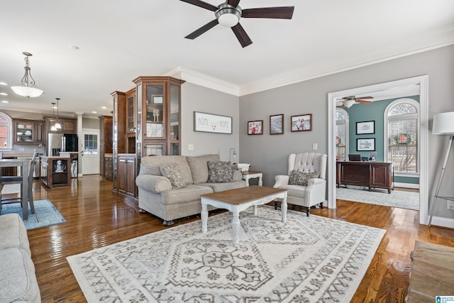 living room with ceiling fan, dark wood-type flooring, and ornamental molding