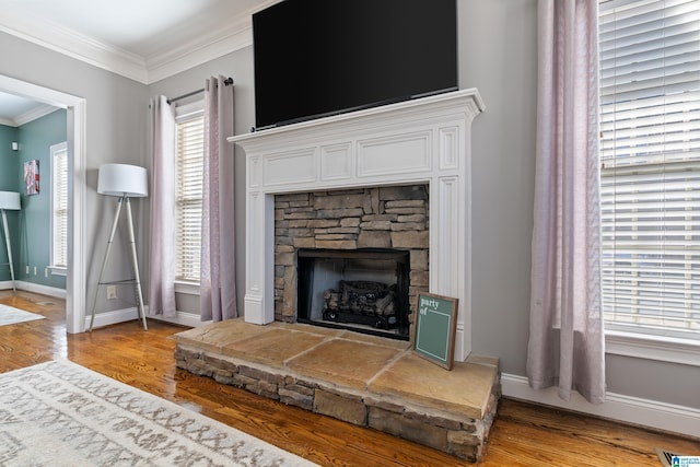 living room featuring light wood-type flooring, a fireplace, and ornamental molding